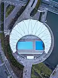 Das Schwimmstadion mit seiner halbmondförmigen Überdachung (März 2018)