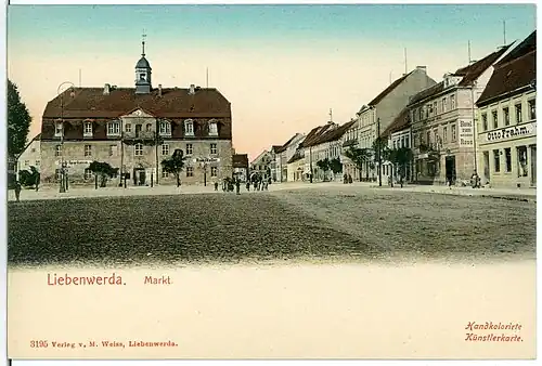 Liebenwerdaer Markt um 1903 auf einer zeitgenössischen Ansichtskarte. Das Hotel „Zum Weißen Roß“ ist rechts im Bild zu sehen.