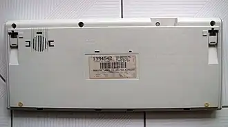 Rückseite einer Model M von 1994, Art. Nr. 1394542 aus Lexmark-Produktion. Am oberen Rand sind die vier unüblichen und tief versenkten 5,5-mm-Sechskantschrauben zu sehen. In der Mitte das Identifikationslabel.