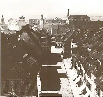 Straße mit am westlichen Ende (Hauptwindrichtung) beidseitig vorspringenden Häusern bildet einen geschützten Platzraum. Spitalstraße vor 1896