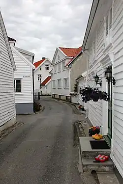 Foto einer engen Gasse, die von weißen Holzhäusern gesäumt ist