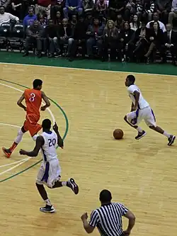 Der linke Spieler (#20) fordert einen Alley oop an, indem er den rechten Zeigefinger hebt.