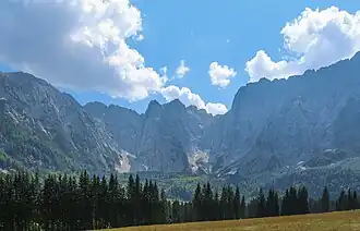 Blick in den Talschluss am Lago di Fusine superiore (Oberer Weißenfelssee): Mittig Veunca und schrägrechts dahinter Monte Termine; links Ponza und Strugova; rechts Piccolo Mangart und Mangart-Ostgrat