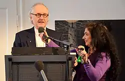 Verstellung eines Mikrofonständers hinter einem Rednerpult auf Mundhöhe