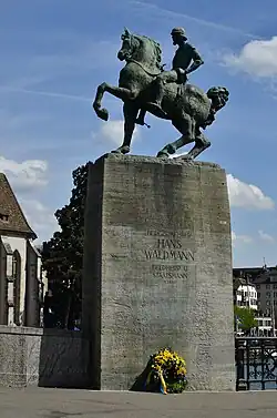 Hans Waldmann, Reiterstandbild auf dem Münsterhof bei der Münsterbrücke in Zürich mit Kranz der Zunft zum Kämbel anlässlich des Sechseläutens am Sockel angelehnt