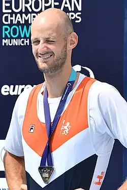 Sander de Graaf trägt das niederländische Nationaltrikot über einem weißen T-Shirt. Um den Hals hängt ein blaues Band, an dem die Silbermedaille befestigt ist.