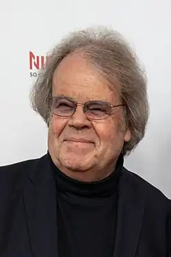 Holm Dressler mit leicht getönter Brille vor weißem Hintergrund