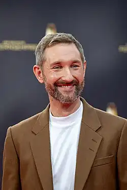 Daniel Boschmann in braunem Sakko und weißem Pullover