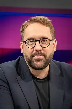 Porträt Paul Ronzheimer vor Studiokulisse Maischberger