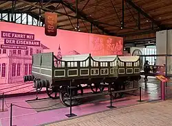 Offener Personenwagen aus Holz von 1843. Der Wagen hat noch kein Dach. Die Fahrgäste saßen im Freien und waren nur durch im Sitzen hüfthohe seitliche Brüstungen gegen Herausfallen geschützt.