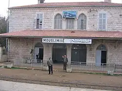 Bahnhof Muslimiyya (Mouslimié), Syrien. Man beachte die unterschiedliche Transkription des Ortsnamens der beiden Bahnhofsschilder.