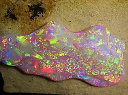 Brasilianischer Opal. Das Opalisieren entsteht durch Reflexion und Interferenz des Lichtes zwischen Kieselgelkügelchen (150 bis 400&nbsp;nm).