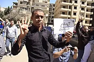 Junge Männer mit R4bia-Gruß