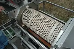 Abbeermaschine geöffnet: Aufsicht auf die Lochgitterwalze mit Stachelwalze und den darunterliegenden Quetschwalzen