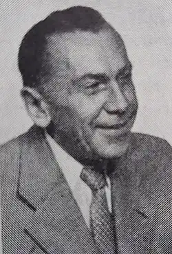 Männliche Person mittleren Alters von vorn nach rechts schauend im hellen Jackett, weißem Hemd und Krawatte in schwarzweiß ab oberen Brustkorb.