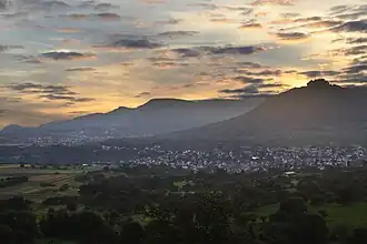 Albtrauf, Mittlere Schwäbische Alb, gesehen vom Osthang (575&nbsp;m) des Jusibergs (672,6&nbsp;m). Die Orte sind Neuffen und Beuren. Den Albtrauf bilden Hohenneuffen (745,4&nbsp;m), Bassgeige (735,6&nbsp;m), westlich von Beuren der Engelberg (527,2&nbsp;m) und weiter hinten der Teckberg (774,8&nbsp;m) mit vorgelagertem Schwäbischen Vulkan Hohenbol (602,2&nbsp;m). Am Albtrauf liegt ausladender Hangschutt. Das Vorland mit den beiden Orten ruht auf Schichten des Braunen Jura.
