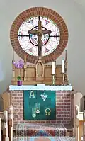 Altar mit Fensterrose im Hintergrund