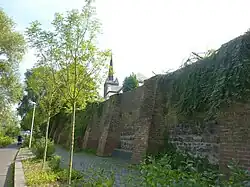 Die erhaltene Klostermauer mit dem neugotischen Turm von St. Margaretha im Hintergrund