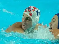 Anđelo Šetka ist im Wasser. Er trägt die mit weiß-roten Quadraten gekennzeichnete Bademütze mit der Nummer 11.