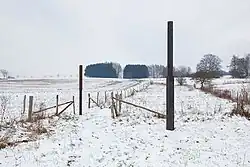 Ansgar Nierhoff, Beziehungen gegen Bedingungen Zwei Streckungen über (eine) Achse auf fremdem Gebiet, 1987, Zwei geschmiedete, gegenläufige Streckungen, mittig abgesetzt, Höhe 4050, Durchmesser bzw. Quadrat 16 × 20 cm, Stahl. Standort: im Tal (Skulpturenpark) zwischen Hasselbach und Werkhausen
