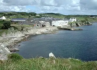 Die Ardbeg-Brennerei mit einigen Häusern der Siedlung Ardbeg im Hintergrund