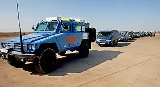 Gepanzerte Fahrzeuge des WFP eskortieren UN-Fahrzeuge mit den sterblichen Überresten von Opfern von Bombenanschlägen im Irak, 2003