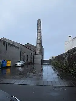 Gebäudekomplex mit Industrieschlot und gepflastertem Hof