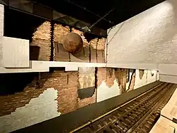 Nieuwmarkt, Amsterdam: Jan Sierhuis: Ohne Titel (1980) Selbstkritische (oder zynische?) Arbeit, die den heftig umstrittenen Abbruch von Wohngebäuden im Zuge des Streckenbaus thematisiert