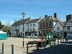 Blick auf den Marktplatz mit Gebäudefront im Hintergrund in Farbe.