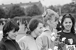 Auf diesem Schwarzweißfoto stehen die beiden Französinnen in dunkler (blauer) Kleidung außen und rahmen die beiden Niederländerinnen in heller (orangefarbener) Kleidung ein.