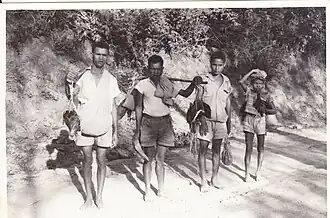 Männer mit Ferkeln auf dem Weg zum Markt in Atsabe (1968/70)