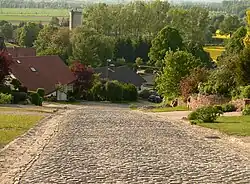 Denkmalgeschützte Straße in Hagenohsen mit Kopfsteinpflaster und 20 % Steigung hinauf zum Festgelände