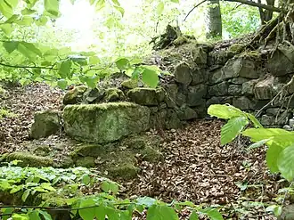 Andere Sicht auf Burgmauer und Hausreste mit unterschiedlich großen Bauquadern