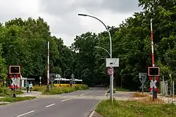 Blick vom Bahnübergang am Bahnhof Johannesstift zur Schönwalder Straße Richtung Spandau, 2015; an der Wendeschleife der heutigen Buslinie M45 befand sich die Kehranlage der Straßenbahn, nach links verlief das Verbindungsgleis zur Bötzowbahn
