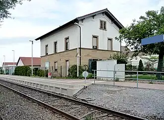 Bahnsteig, im Hintergrund das frühere Bahnhofsgebäude