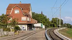 Bahnhofsgebäude mit Mansardendach und gekuppelten Fenstern