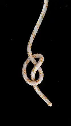 Man betrachte die Stelle, an der eine Part in der Mitte des Überhandknotens über die andere geht. Die Part zeigt den Buchstaben Z. Der Knoten ist rechtsgängig und wird gelegentlich auch als rechts geknoteter Überhandknoten bezeichnet.