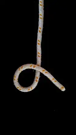 Zuerst wird ein Auge mit der Schlagrichtung links gelegt. Das heißt, man legt die lose über die stehende Part. Die Schlagrichtung ist deshalb links, weil von oben nach unten die Windung nach links (entgegen dem Uhrzeigersinn) nach unten führt.