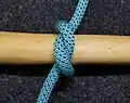 Halber Knoten. Die Seilenden laufen ca. 180° aus dem Knoten. Würde man die Stange aus dem Knoten ziehen, erhielte man einen Überhandknoten