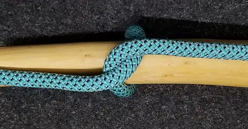 Ein „Halber Schlag um eine Stange“ Auch ein Törn um eine Stange, aber er wird Halber Schlag genannt, weil die Leine gedreht ist und die stehende Part das Arbeitsende bekneift. Würde man die innenliegende Stange aus dem Halben Schlag herausziehen, erhielte man ein Auge.