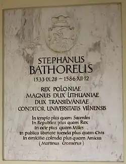 Farbfotografie einer Gedenktafel mit der Aufschrift „Stephanus Bathoreus 28.09.1533 – 12.12.1586 Rex Poloniae. Magnus Dux Lithuaniae. Dux Transilvaniae. Conditor Universitatis Vilnensis“. Eine Widmung von Martin Cromer steht darunter und an der Spitze ist ein Wappen mit einem Reiter.