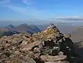 Der Gipfelcairn des Beinn Tarsuinn, im Hintergrund links Beinn Dearg Beag und Beinn Dearg Mòr, rechts das Massiv des An Teallach