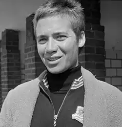 Auf diesem Schwarzweißfoto ist Betty Heukels mit einer hochgeschlossenen Trainingsjacke zu sehen, darüber trägt sie einen Bademantel.