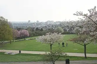 Frühling: Blick auf Seckbach mit ev. Marienkirche, Atzelberg und Hochhäusern der Innenstadt