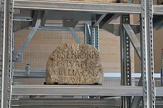 Kalksteinblock mit Inschrift.