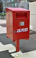 Postbriefkasten in Belgien mit der Aufschrift De Post, der alten niederländischen Bezeichnung für bpost.