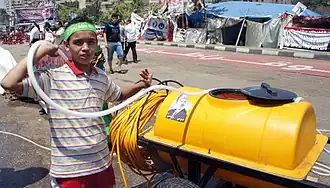 Durch Abspritzen kühlt ein Junge Demonstranten in der Augusthitze ab.[67]