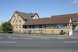 Das Wasserrad befand sich an dem flachen Gebäude etwa hinter dem Pfeilwegweiser Ortshinweisschild