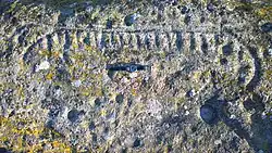 Schiffspetroglyph und verschieden große Schalen