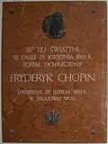 Gedenktafel in der Kirche des Heiligen Rochus und Johannes des Täufers von Brochów, mit dem Schriftzug: In diesem Gotteshaus wurde am 23.&nbsp;April 1810 Fryderyk Chopin getauft geboren am 22.&nbsp;Februar 1810 in Żelazowa Wola .